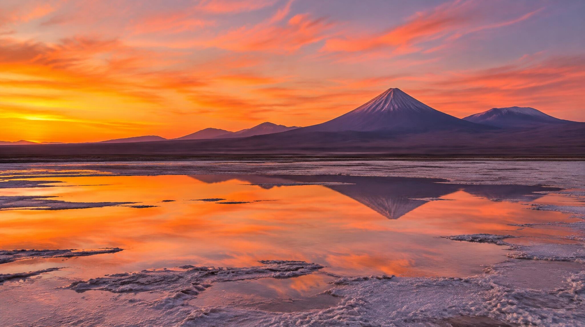 Atacama desert salt flats at dusk with volcano